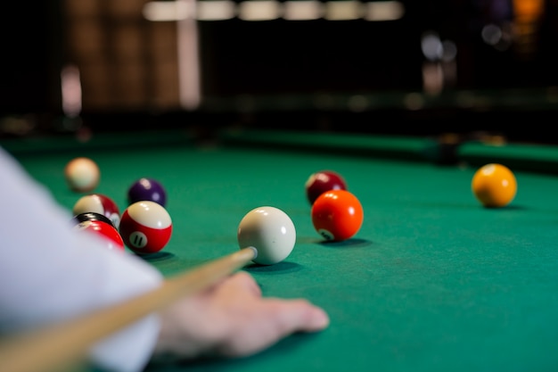 Close-up boy with pool cue playing billiard