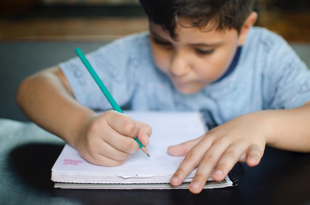close-up of boy writing homework