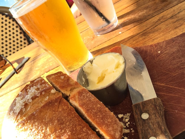 Foto close-up di pane e burro con birra sul tavolo