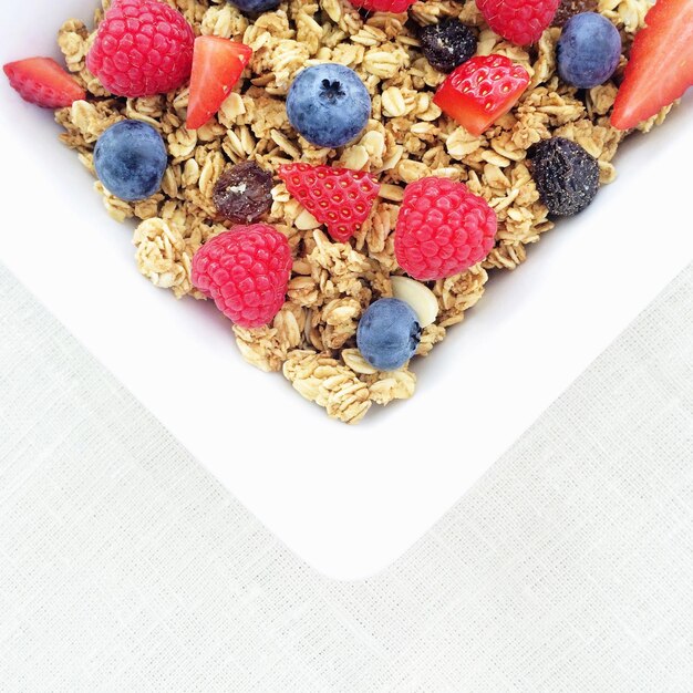 Foto close-up di cereali per la colazione con bacche in piatto