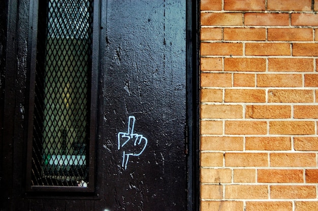 Photo close up of brick wall with a fuck you sign