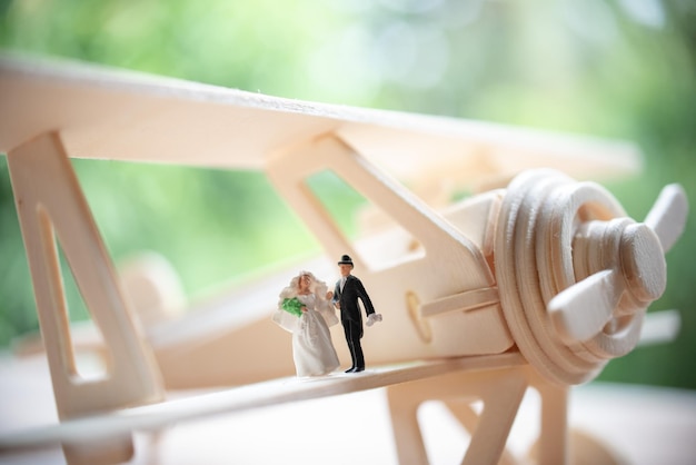 Photo close-up of bride and groom figurines on model airplane