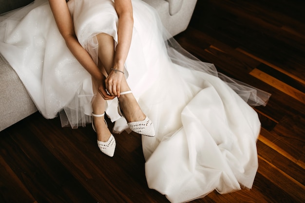 Close-up of a bride putting on flat wedding shoes