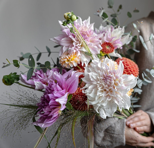 Primo piano di un bouquet festivo luminoso con crisantemi in mani femminili.