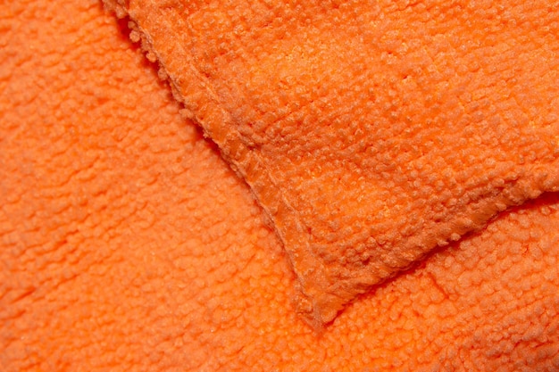 A close up of a bright orange fabric with a seam.