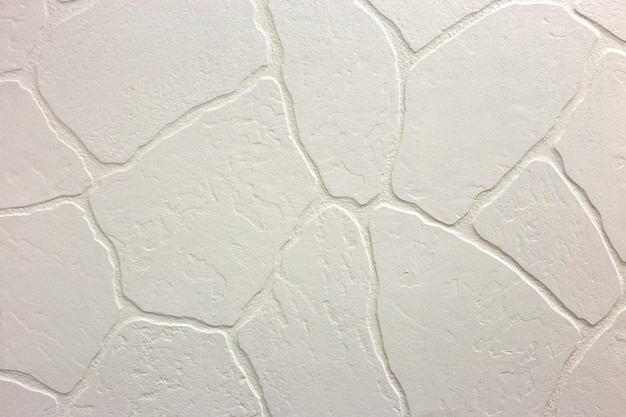 明るい白い漆喰の不均一な漆喰壁のクローズアップ。抽象的なテクスチャ、カオスコピースペース。装飾的なグランジスペース。