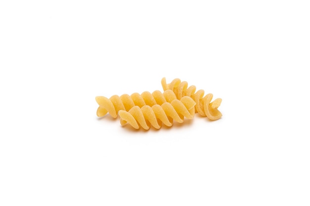 사진 흰색 배경에 밝은 노란색 익히지 않은 fusilli 파스타를 닫습니다.