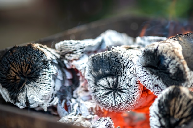 Close up of brightly burning wooden logs with yellow hot flames of fire.