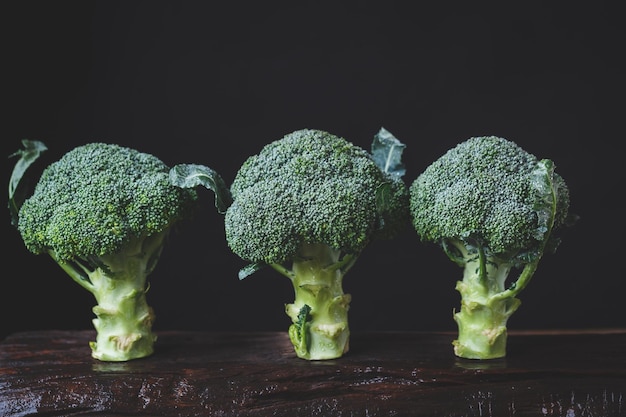 Foto close-up di broccoli su un tavolo di legno su sfondo nero