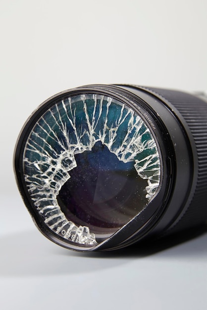 Close-up of broke camera lens against white background