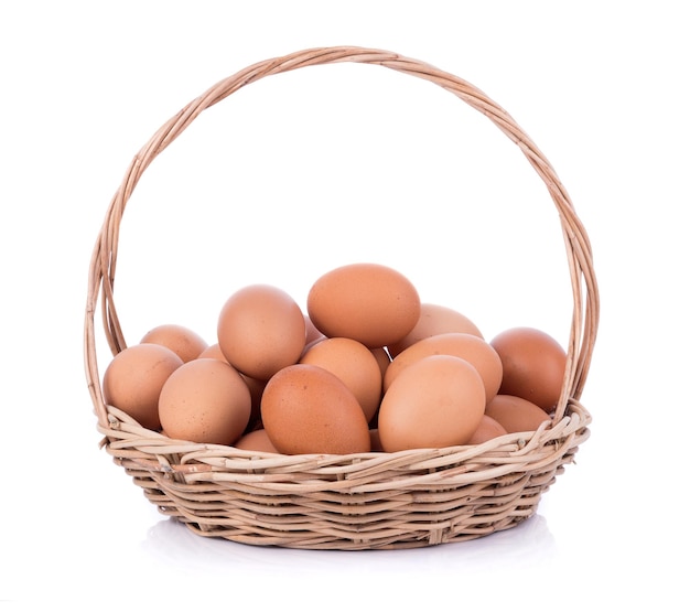 Photo close-up of brown eggs in basket on white background