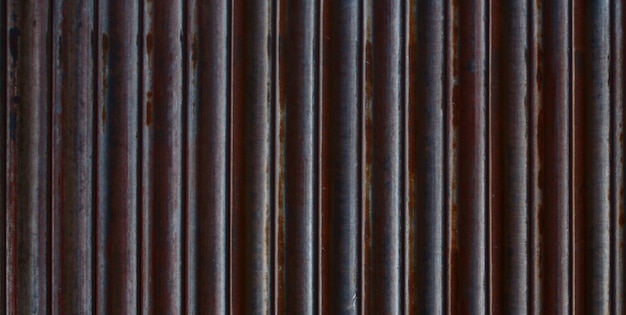 A close up of a brown metal wall with rusted lines.