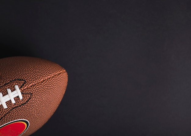 Photo close-up of brown rugby ball on black background