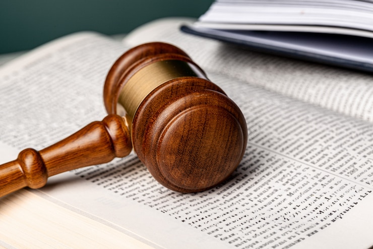 Photo close up of a brown wooden gavel and book