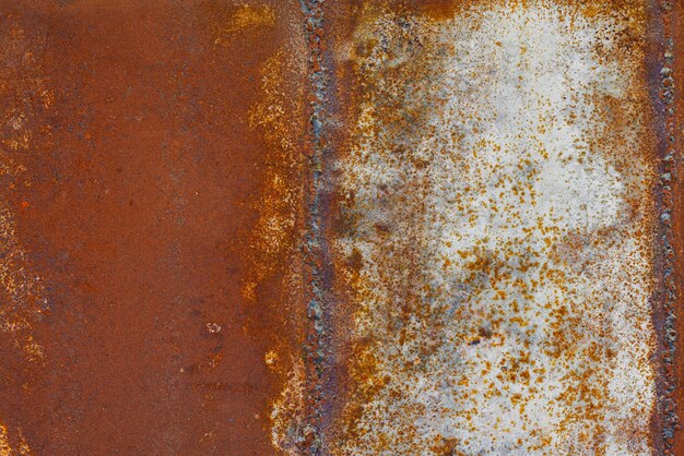 Photo close up of a brownish rusted welded sheet metal surface with yellowish and orange hue
