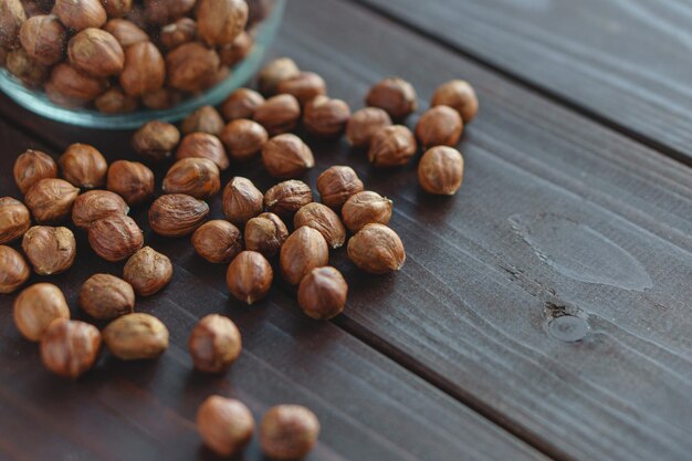 Close-up bruine hazelnoot in glazen pot en op houten bureau. Gezonde biologische vegetarische snack hazelnoot