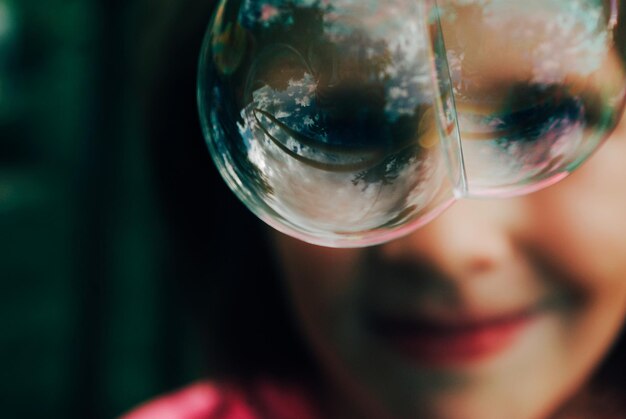 Photo close-up of bubble with girl in background