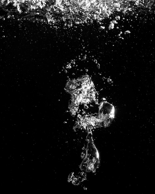 Photo close-up of bubbles over sea against black background