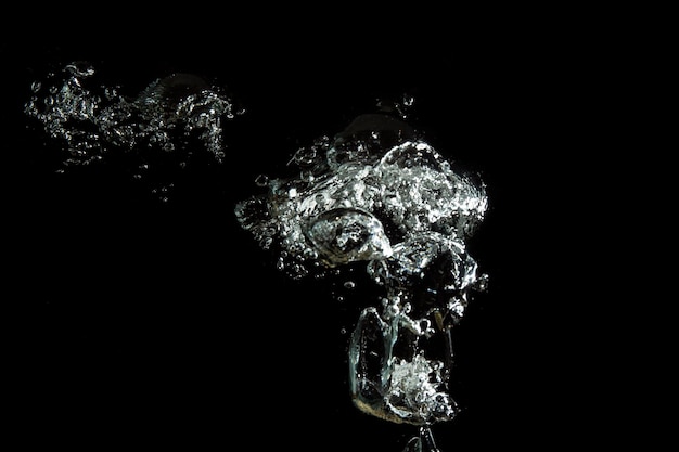 Photo close-up of bubbles over sea against black background