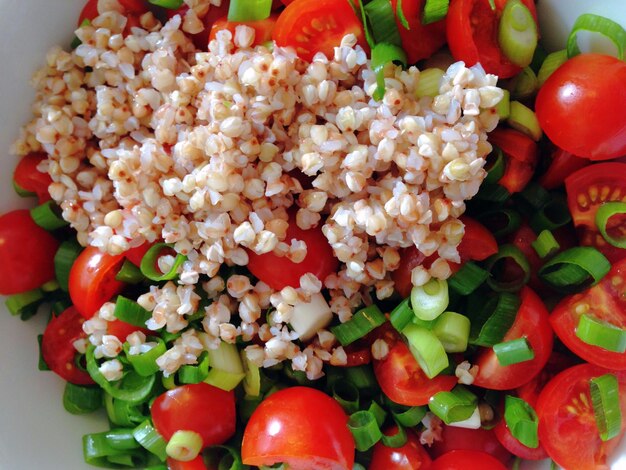 Photo close-up of buckwheat with tomato in bowl