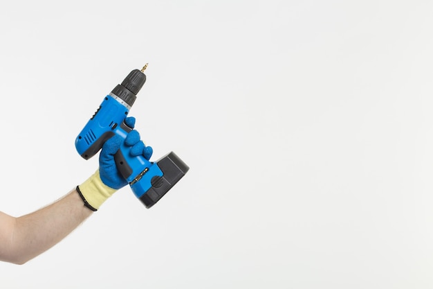 Close-up of builder's hand with screwdriver wearing gloves on white background with copy space.