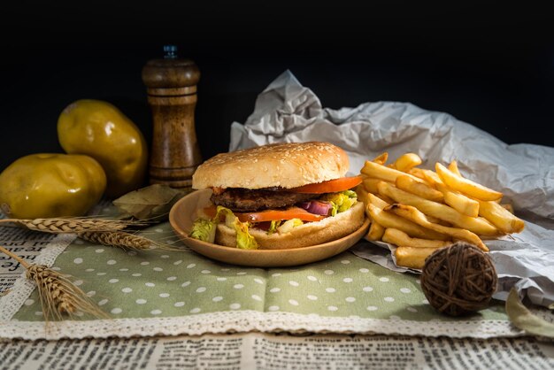 Foto close-up di hamburger e patatine fritte sul tavolo contro uno sfondo nero