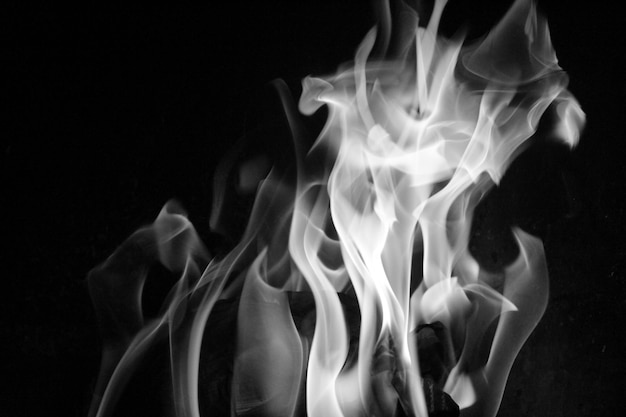 Photo close-up of burning candle against black background