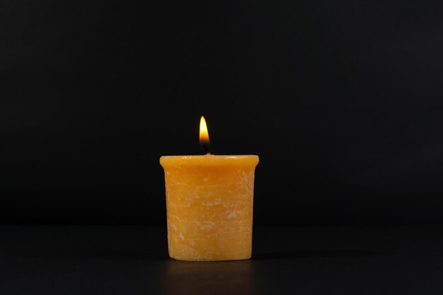 Close-up of burning candle against black background