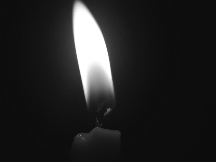 Photo close-up of burning candle over black background