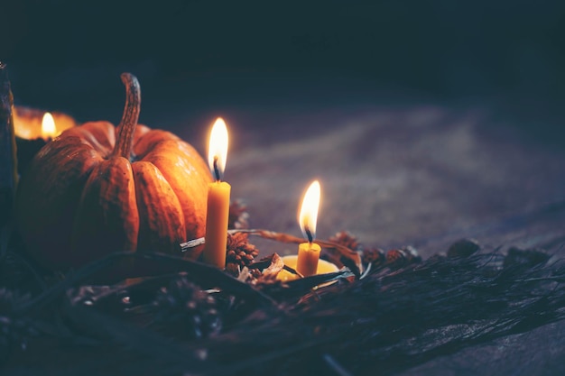 close-up of burning candles and pumpkin on table