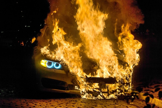 Photo close-up of burning car on street at night