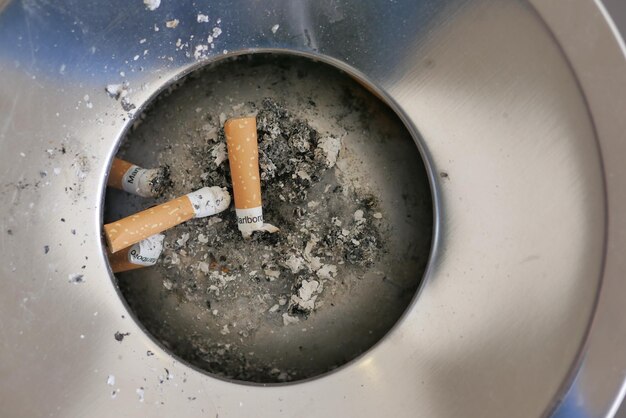 Close up burning cigarette in ashtray on table