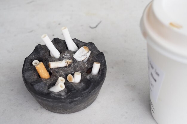 Close up burning cigarette in ashtray on table