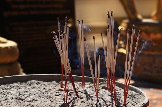 Close-up of burning incense in container at temple