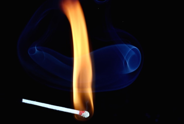 Photo close-up of burning match against black background