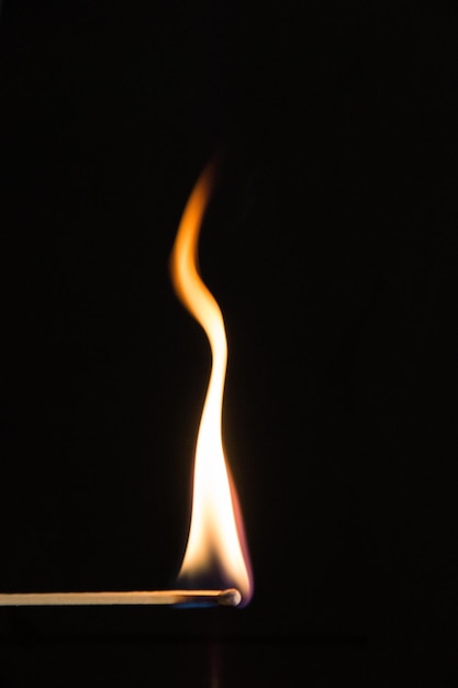 Photo close-up of burning matchstick against black background