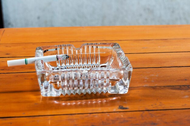 Close-up of burnt cigarette in ashtray on wooden table