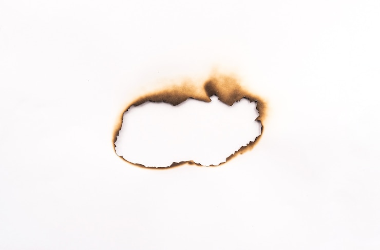 Photo close up of burnt holes with paper isolated