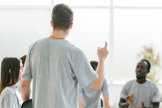 Close up business coach holds a debate with a group of young people