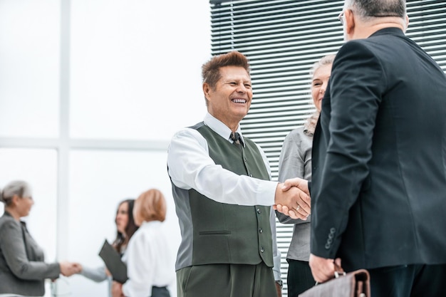 Close up business colleagues greet each other with a handshake