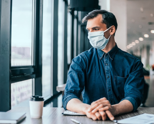 Close up. business colleagues in protective masks working with financial documents .