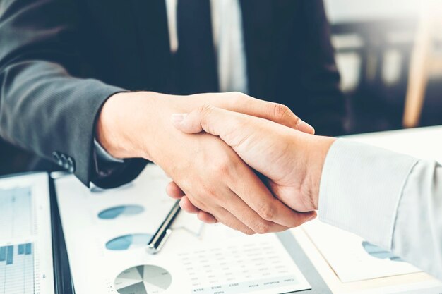 Close-up of business colleagues shaking hands in office