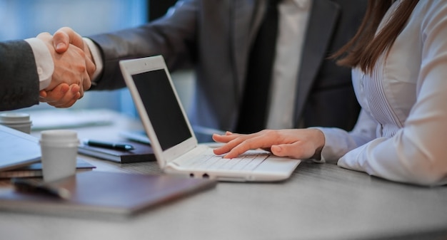 Close up. business colleagues shaking hands over a work Desk . concept of cooperation.