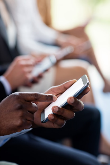 Close-up of business executives using mobile phone