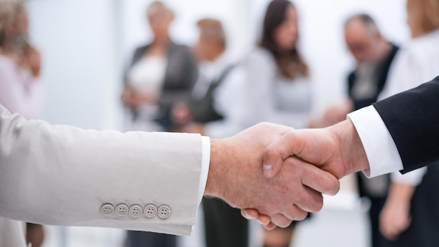 Close up business handshake on office background