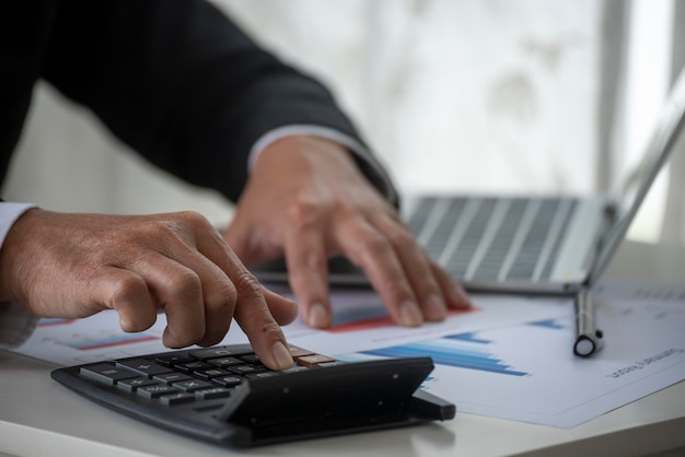 Close up business man hands using calculator counting tax\
financial bill man hands calculating