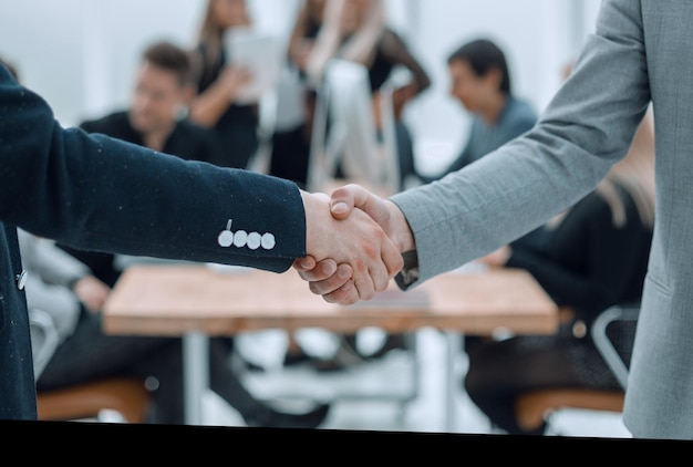 Close up business partners boldly shaking hands