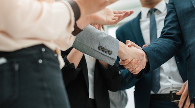 Close up business partners shaking hands in the office