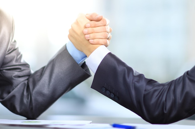 Photo close up business people compete in arm wrestling