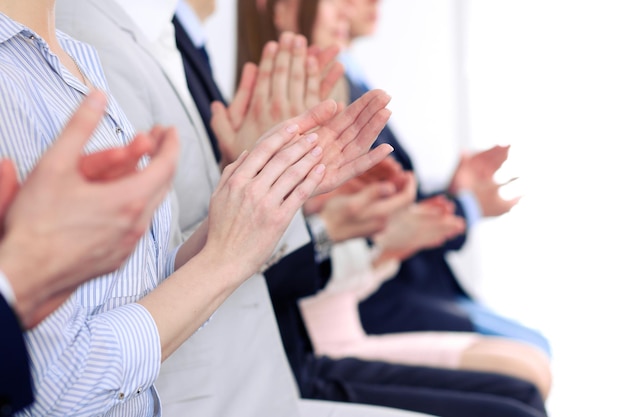 Close up of business people hands clapping at conference